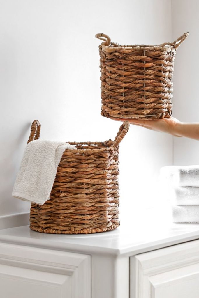 Stylish wicker baskets with towels in a bright, modern bathroom setting, showcasing minimalistic interior design.